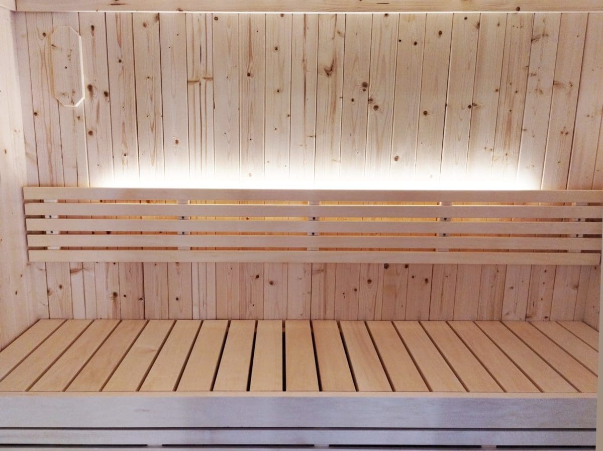 A scaled image showing the spacious interior of the SaunaLife Model X7 Indoor Sauna, highlighting its premium Nordic Spruce wall panels and comfortable dual-tier benching designed for enhanced sauna bathing experience.